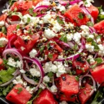 Feta Watermelon Salad Recipe topped with feta crumbles, fresh herbs, and sliced red onion