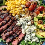 Grilled Balsamic Steak Salad Recipe with sliced steak, grilled corn, avocado, onions, and Gorgonzola cheese