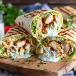 Healthy grilled chicken ranch wraps with lettuce and ranch sauce served on a wooden board