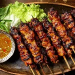 Grilled Thai Coconut Chicken Skewers with caramelized glaze served with dipping sauce and fresh lettuce