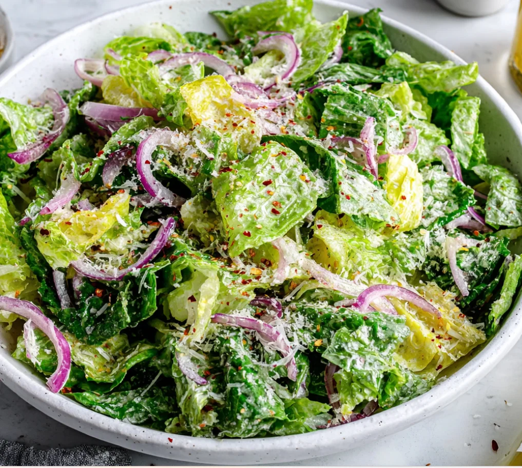 Lemon Parmesan Lettuce Salad Recipe with crisp romaine, parmesan cheese, red onions, and red pepper flakes in a white bowl