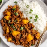 Mexican Picadillo served with white rice, lime wedges, and fresh cilantro
