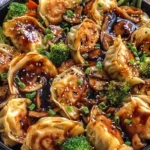 Potsticker Stir Fry topped with sesame seeds, green onions, broccoli, and mushrooms in savory stir fry sauce