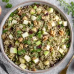Quinoa Apple Salad topped with apples, cranberries, walnuts, and fresh mint in a large bowl