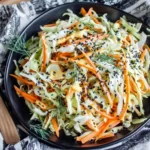 Simple Easy Cabbage and Carrot Salad served with fresh dill and sesame seeds in a rustic black bowl