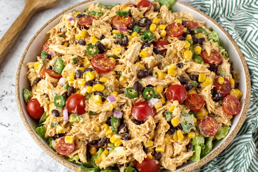 Creamy Southwest Chicken Salad served over lettuce with corn, black beans, and tomatoes