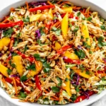Thai Mango Chicken Salad with shredded chicken, mango, cabbage, carrots, and creamy peanut dressing