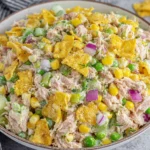 Viral Tuna Salad with crunchy jalapeño chips, corn, peas, and creamy dressing in a bowl