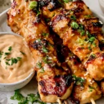 Bang Bang Chicken Skewers served with creamy homemade bang bang sauce and fresh herbs