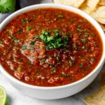 Blender Salsa Recipe in a serving bowl with tortilla chips, lime, and fresh cilantro garnish