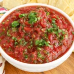 Blender Salsa with Fresh Tomatoes served in a white bowl with tortilla chips and fresh cilantro