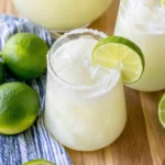 Brazilian Lemonade in a frosty glass with ice cubes and fresh lime garnish
