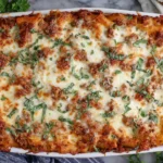Classic Baked Ziti baked in a casserole dish with golden melted cheese, meat sauce, and fresh basil garnish