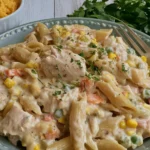 Crock Pot Chicken Pot Pie Pasta served on a plate with shredded chicken, penne pasta, mixed vegetables, and creamy sauce.
