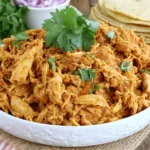 Crock Pot Chicken Taco Meat made with tender shredded chicken, taco seasoning, and butter in a serving bowl