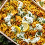 Dump-and-Bake Chicken Tzatziki with Rice baked in a casserole dish with golden rice, juicy chicken, tzatziki sauce, and fresh herbs