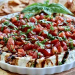 Easy Bruschetta Dip Recipe topped with fresh tomatoes, basil, and balsamic glaze served with pita chips and toasted baguette.