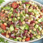 Easy Fresh Mediterranean Bean Salad with chickpeas, kidney beans, cucumber, tomatoes, and fresh herbs in a serving bowl
