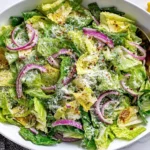 Easy Lemon Parmesan Lettuce Salad topped with parmesan cheese, red onion, lemon wedges, and red pepper flakes