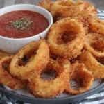 Extra Crispy Homemade Onion Rings with a golden breadcrumb coating and dipping sauce