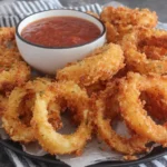 Extra Crispy Homemade Onion Rings served with dipping sauce on a platter