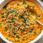 Spicy Red Lentil Curry in a bowl with fresh cilantro garnish and golden spoon, ready to serve with crusty bread