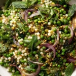 Spring Couscous Salad featuring pearl couscous, green peas, mint, arugula, pistachios, and marinated red onions