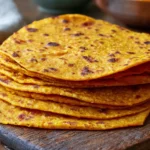 Sweet Potato Tortillas stacked on a rustic wooden board, easy gluten-free vegan tortillas made with mashed sweet potato