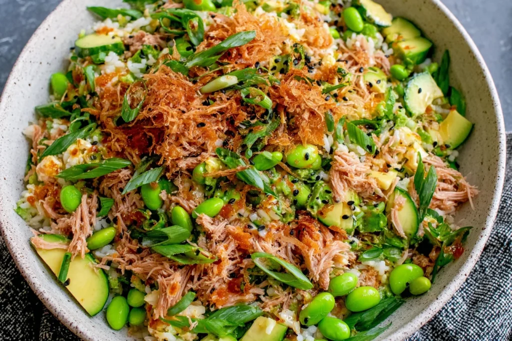 Tuna Avocado Crispy Rice Salad with crispy rice, avocado, edamame, cucumber, and sesame toppings in a bowl