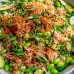 Tuna Avocado Crispy Rice Salad with crispy rice, avocado, edamame, cucumber, and sesame toppings in a bowl