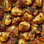 Crispy Coconut Peach Chicken bites coated in golden coconut crust and tossed in sweet savory peach sauce with herbs