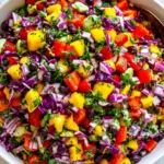 Fresh Black Bean Mango Salad with vibrant mango chunks, black beans, red cabbage, bell peppers, and cilantro in a bowl