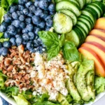 Peach Berry Summer Salad with sliced peaches, blueberries, cucumber, avocado, feta, and pecans on fresh lettuce