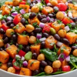 Sweet Potato Black Bean and Chickpea Salad with roasted sweet potatoes, chickpeas, black beans, fresh herbs, and colorful vegetables in a bowl