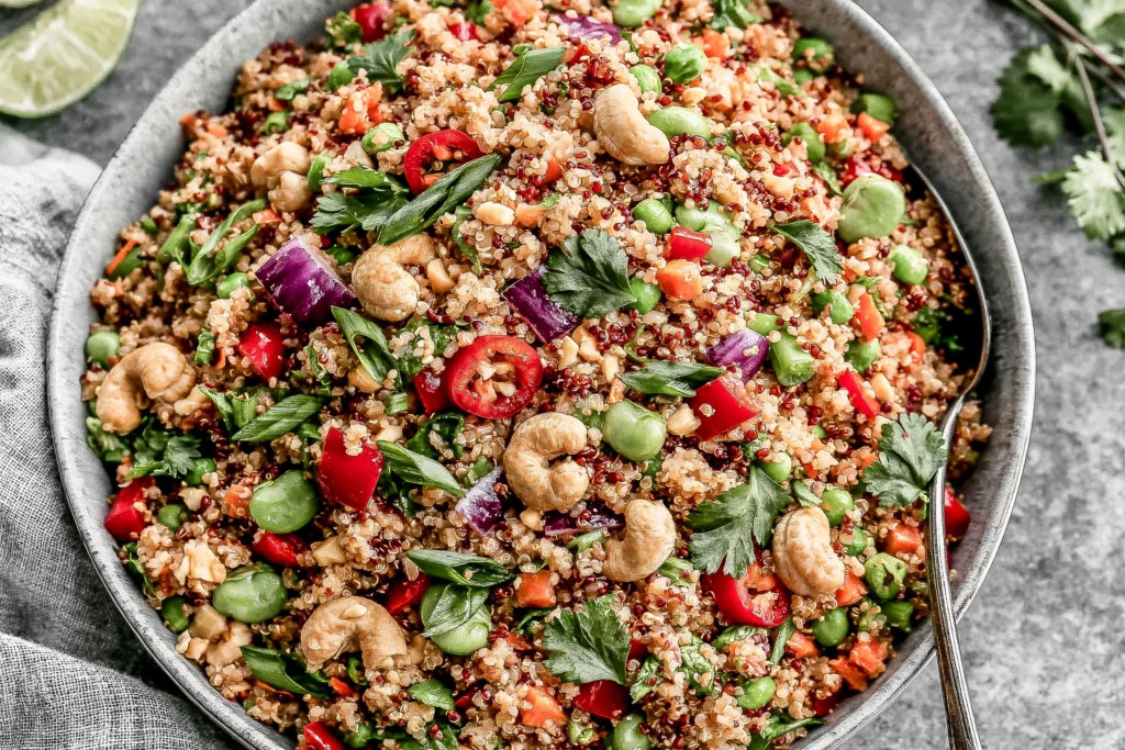 Thai Quinoa Salad with peanut dressing, fresh vegetables, edamame, and cashews in a vibrant healthy bowl