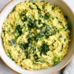 Anti-Inflammatory Creamy Coconut Rice with spinach, bok choy, turmeric, and herbs in a bowl