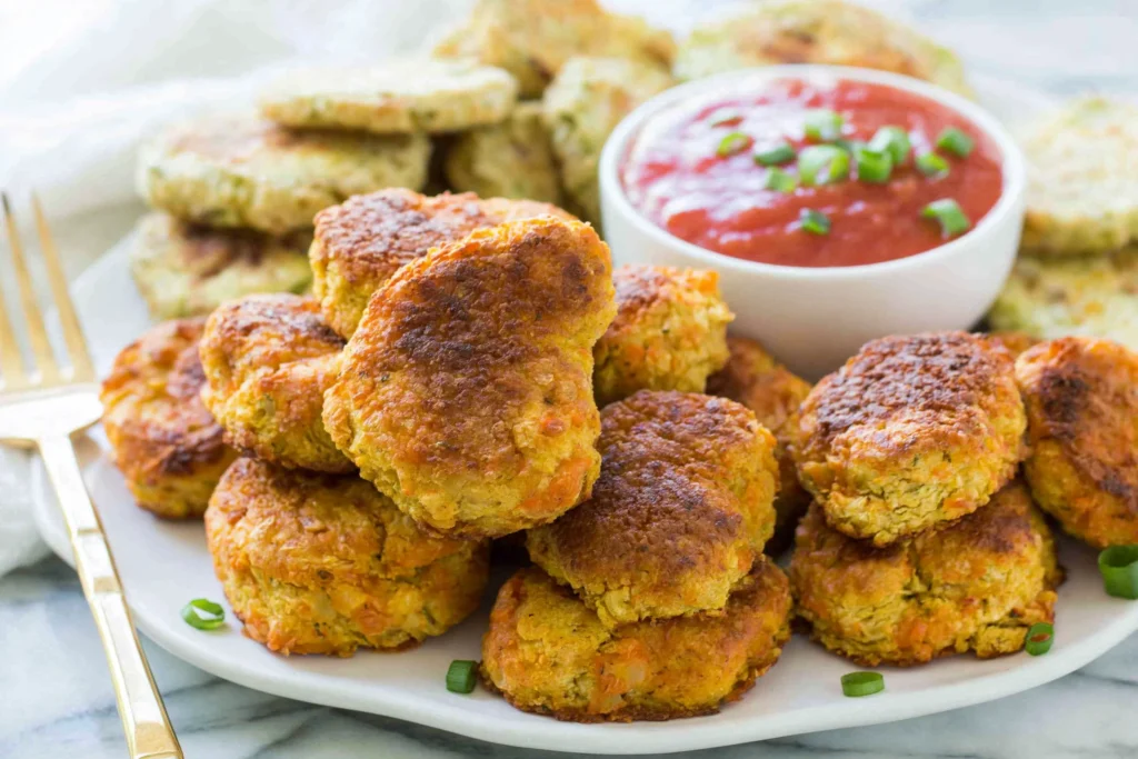 Crispy golden Chickpea Vegetable nuggets served with dipping sauce on a plate