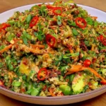 Crispy Rice Salad with Peanut-Chili Dressing loaded with avocado, edamame, shredded carrots, fresh herbs, and sliced red chili peppers