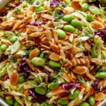 Crunchy Cabbage and Edamame Salad with sesame ginger dressing, toasted almonds, shredded cabbage, carrots, and green onions