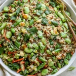 Crunchy Quinoa Edamame Salad with sesame-ginger dressing, fresh vegetables, and toasted almonds in a vibrant healthy bowl