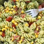 Chimichurri Pasta Salad with rotini pasta, corn, tomatoes, and fresh herb chimichurri sauce in a mixing bowl