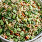 Crunchy Quinoa Edamame Salad tossed with sesame-ginger dressing, fresh herbs, edamame, and quinoa in a healthy vibrant bowl