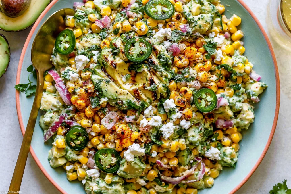 Fiesta Avocado Corn Salad with charred corn, creamy avocado, jalapeños, and Cotija cheese in a vibrant bowl