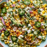 Fiesta Avocado Corn Salad with charred corn, creamy avocado, jalapeños, and Cotija cheese in a vibrant bowl