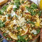 Honey Mustard Quinoa Apple Salad with crispy shallots, sliced apples, arugula, parmesan, and pepitas in a wooden bowl