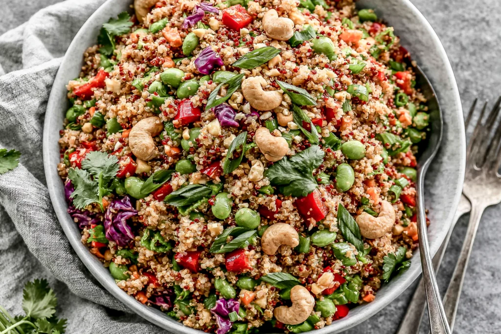 Thai Quinoa Salad with colorful vegetables, edamame, cashews, and creamy peanut dressing in a fresh healthy bowl
