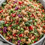 Thai Quinoa Salad with colorful vegetables, edamame, cashews, and creamy peanut dressing in a fresh healthy bowl