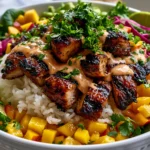 Chicken Mango Rice Bowl with grilled chicken chunks, fresh mango salsa, rice, avocado, and creamy spicy sauce