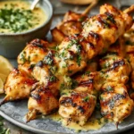 Cowboy Butter Chicken Skewers with creamy garlic butter sauce, grilled chicken, fresh herbs, and lemon on a serving plate