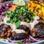 Jerk Chicken & Mango Slaw Bowls topped with grilled chicken, charred mango, cabbage slaw, and creamy honey lime sauce